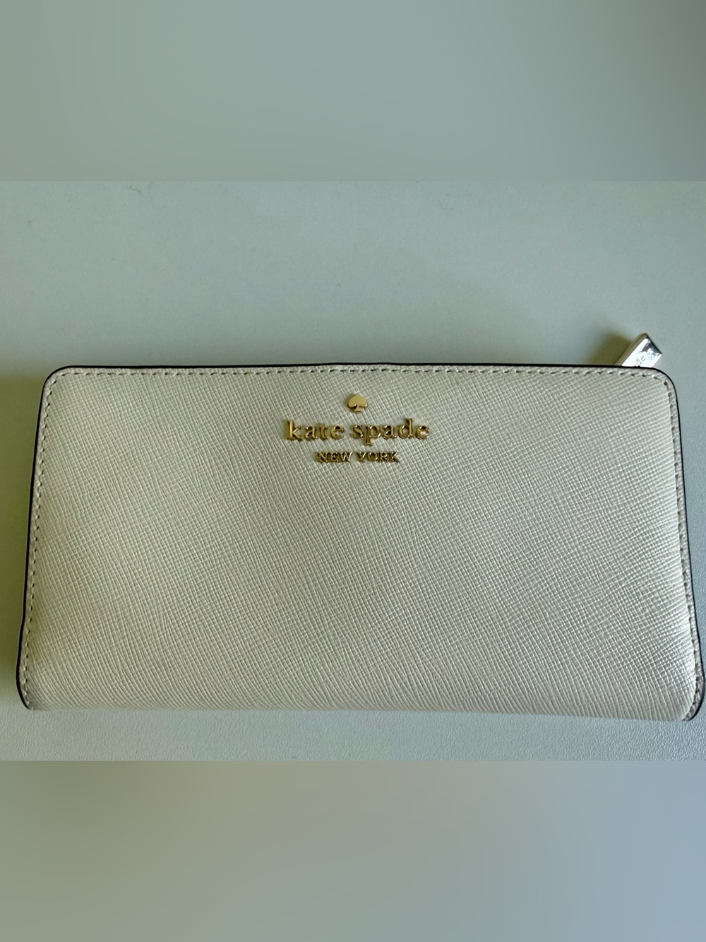 kate spade cream saffiano zip-around wallet with gold logo